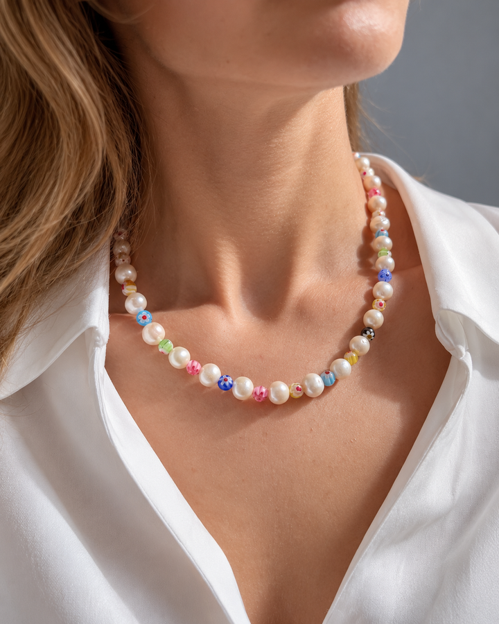 Collar corto de cuentas claras redondeadas con pequeños detalles de varios colores.