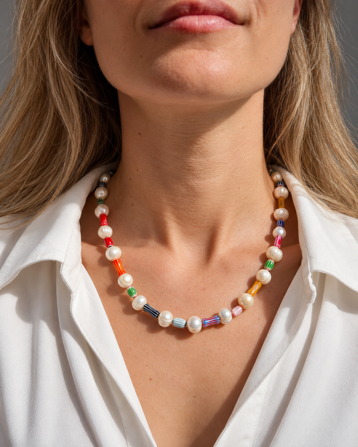 Collar de cuentas claras alternadas con cuentas alargadas de varios colores.