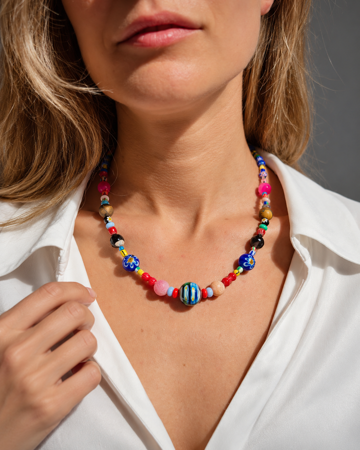 Collar multicolor con cuenta central redonda rayada y dos cuentas azules con motivos florales.